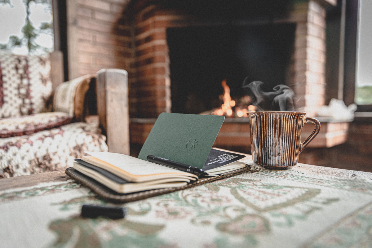 notebook and coffee mug by the fireplace