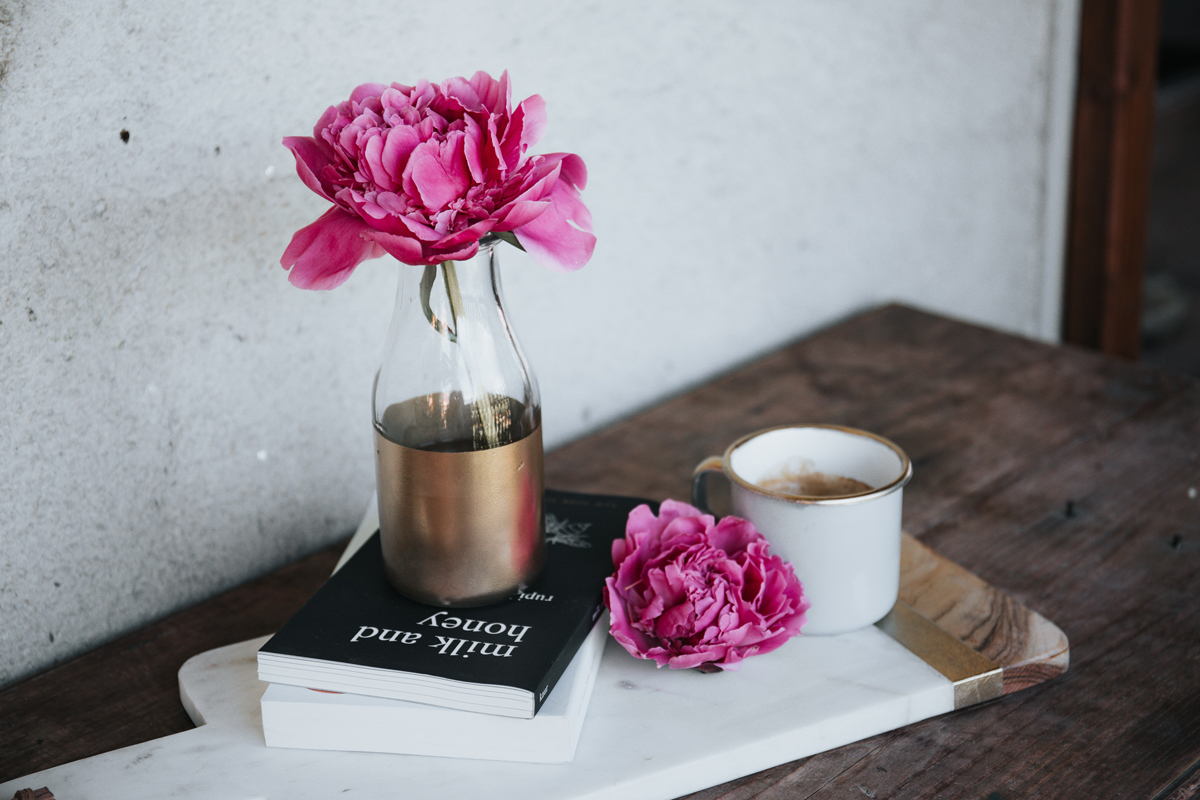 books on table with vase of flowers
