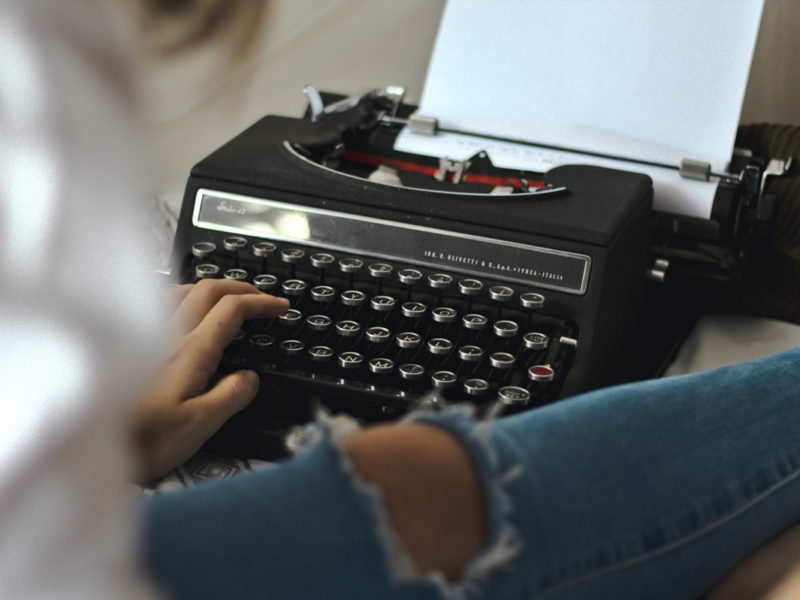 person typing on typewriter