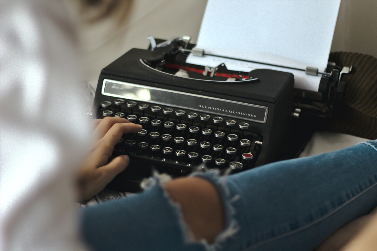 person typing on typewriter