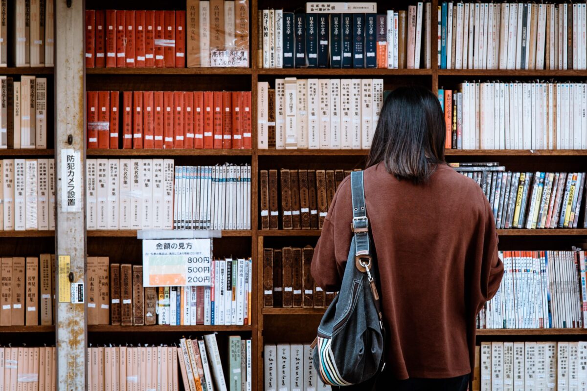 person standing in front of bookshelf at library