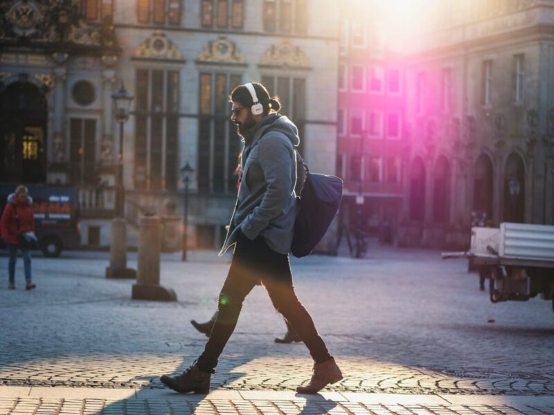 man walking on street listening to audiobook