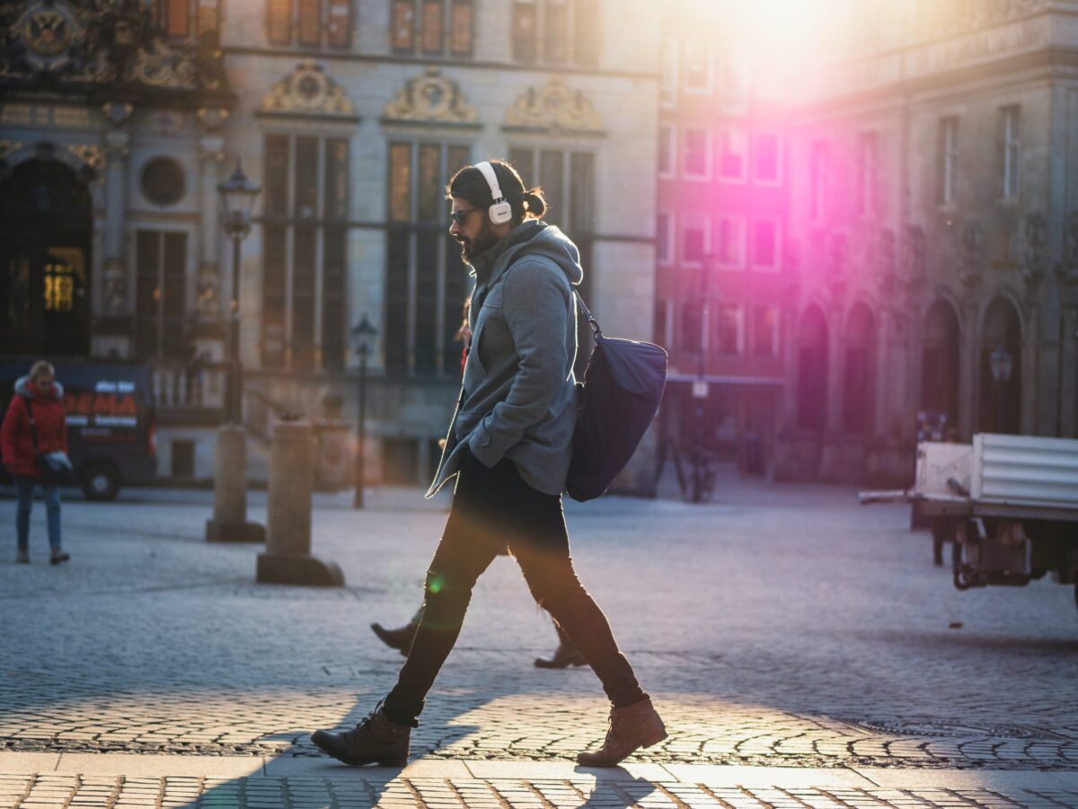 man walking on street listening to audiobook