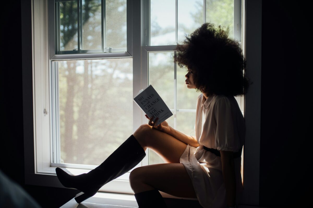 person reading in a windowsill